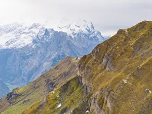 Panoramic view of an autumnal mountain landscape with snow-covered peaks and rocky slopes