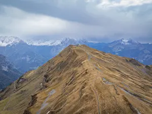 Panoramic view of a barren mountain landscape in autumn with clouds and a path on the summit