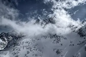 Panoramic view of clouds passing over snowy mountains