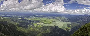Panoramic view from Herzogstand down to a mountain landscape with Lake Kochel and cloudy sky