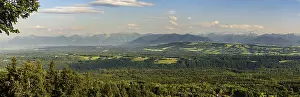 Panoramic view of an idyllic landscape with mountains in the background and extensive forests in the foreground