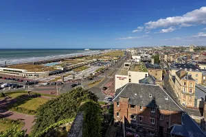 Panoramic view of the town and coast with promenade and hotels under a clear sky