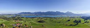Panoramic view of a vast landscape with Lake Forggensee and mountains on the horizon