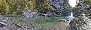 Panoramic view of a waterfall with clear water and autumn trees