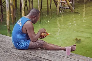 Papua-Diving boatman at lunch, Gam Island in the Dampier Strait