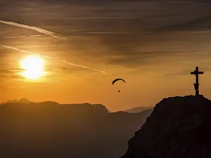 Category Mountain Landscapes Prints: Paraglider flying next to the summit cross of the small Jenner at sunset