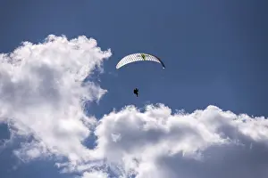 Paraglider soaring in the clear sky