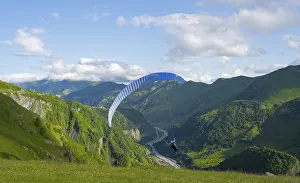 Framed Print : A paraglider soars over a green landscape with wide sky and valley views