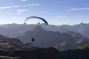 Paragliders on the Nebelhorn, behind mountains of the Allgaeu Alps