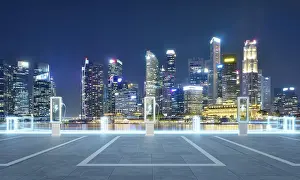 Empty parking lot with ev chargers glowing against the backdrop of singapore's illuminated skyline at night