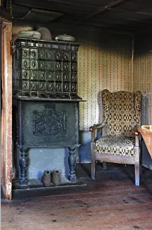 Parlour with tiled stove from 1854 and armchair in a farmhouse