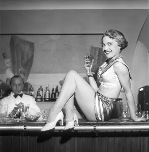 Party in the 1950s. A smiling young woman dressed in a costume however small