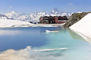 Pass Nufenenpass with snow, restaurant and small mountain lake