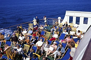 Passagiere sitzen in Liegestuehlen auf dem Deck eines Faehrschiffs und geniessen die Sonne, Schweden, 1970