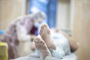 Patient lying in a hospital setting with medical staff in a blurred background