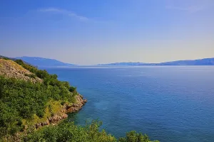 A peaceful coastal landscape with clear blue sea and sunny sky