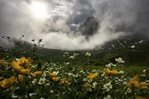 Peaks in the morning light and alpine landscape with dramatic clouds