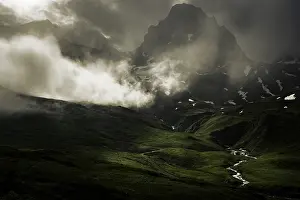 Peaks in the morning light and alpine landscape with dramatic clouds
