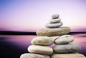 Pebbles stack in peaceful evening with smooth ocean background