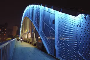 Pedestrian way along the metallic arc structure of Eitai bridge with moving bicycle by night time in Tokyo Japan