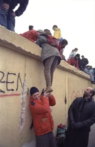 People climbing the Berlin Wall at Brandenburg Gate
