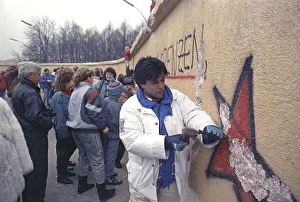 People climbing the Berlin Wall at Brandenburg Gate