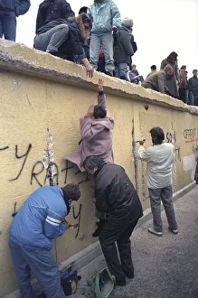 People climbing the Berlin Wall at Brandenburg Gate