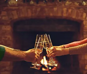 Framed Print : People clinking champagne glasses while gathering around fireplace in country house