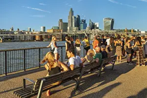 People enjoying the summer evening on the Thames near the Millenium Bridge