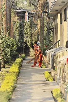 Two people gardening in a hotel corridor