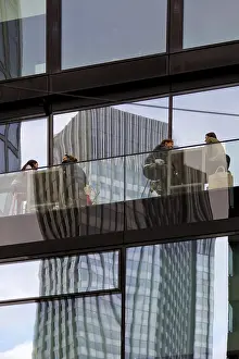 People on the glazed outdoor balcony in a bar with reflection of a skyscraper