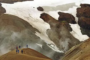 People on a hiking trail in front of snowfields