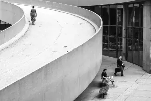 People moving along a curved ramp in a cityscape in Toronto