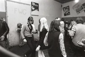 This is how people partied in the 1970s. People dance and drink beer while a band plays live music. Women and men dance to the music, drink beer and smoke in a rather dull party room that everyone somehow seems to enjoy and have fun in. 1970