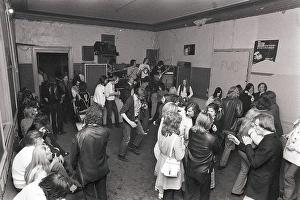 This is how people partied in the 1970s. People dance and drink beer while a band plays live music. Women and men dance to the music, drink beer and smoke in a rather dull party room that everyone somehow seems to enjoy and have fun in. 1970