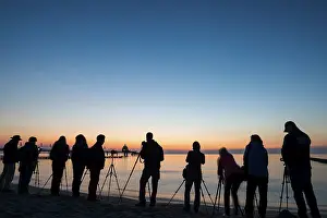 People photographing on the beach near the pier