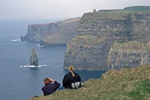 People take pictures at the edge of a cliff
