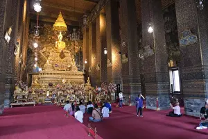People praying, altar with Buddha statue in the Wat Po temple