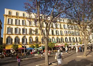 People sitting outside popular cafes on a sunny afternoon in Plaza de la Merced