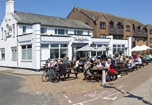 People sitting in sunshine outside the Jolly Sailors pub