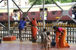 People at station watching train passing