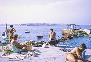 People sunbathing on rocky coastal ledge by Mediterranean Sea, Syracuse, Sicily, Italy, Europe 1969, Europe