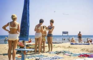People sunbathing on a sandy beach by the sea in Rimini, Emilia Romagna region, Italy 1969