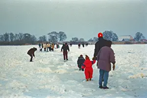 People walk across ice rink, frozen Elbe