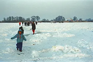 People walk across ice rink, frozen Elbe