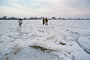 People walk across ice rink, frozen Elbe
