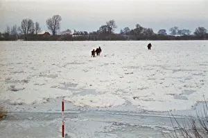 People walk across ice rink, frozen Elbe