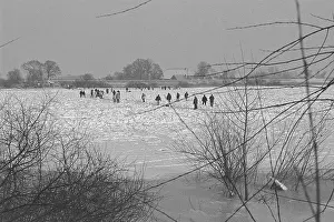 People walk across ice rink, frozen Elbe