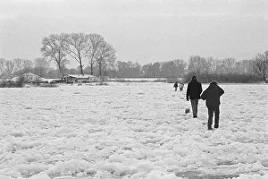 People walk across ice rink, frozen Elbe
