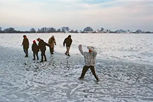 People walk across ice rink, frozen Elbe